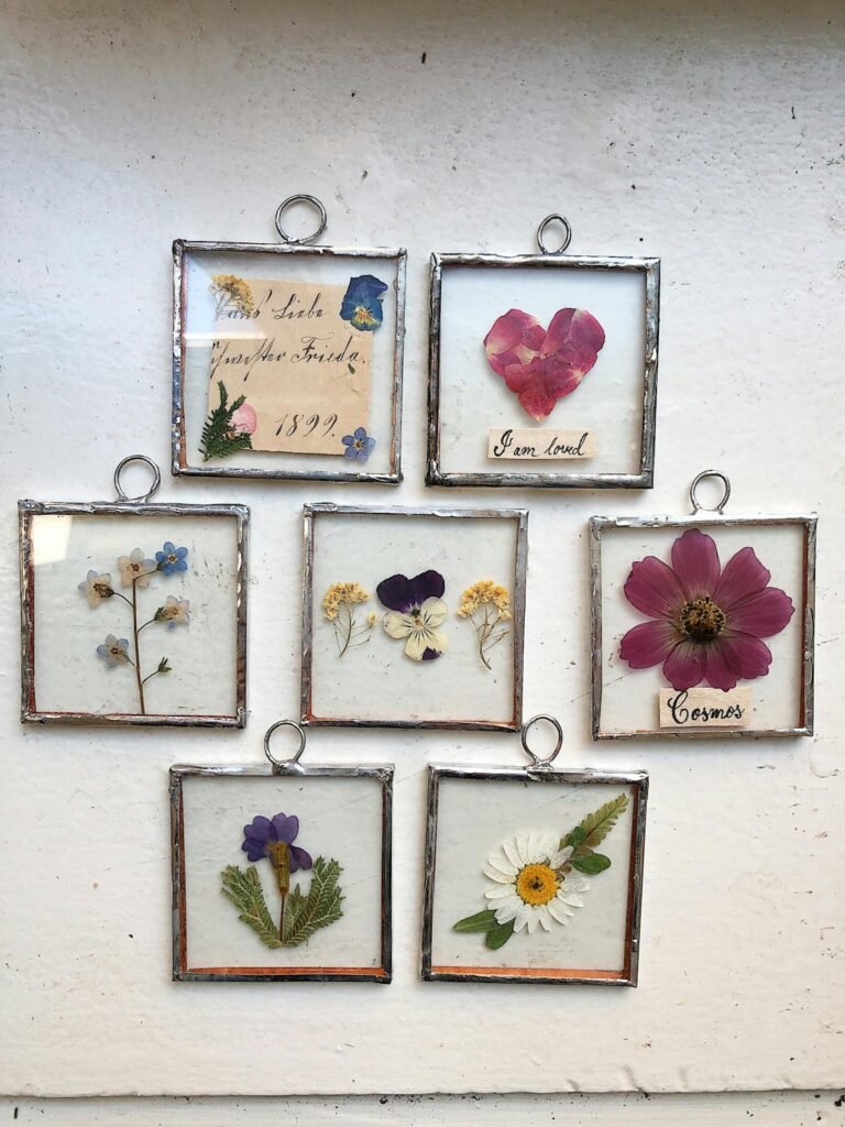 Charming vintage-style pressed flower art pieces in delicate metallic frames.